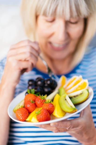 istock Attractive senior woman with fruit lunch 1281753377