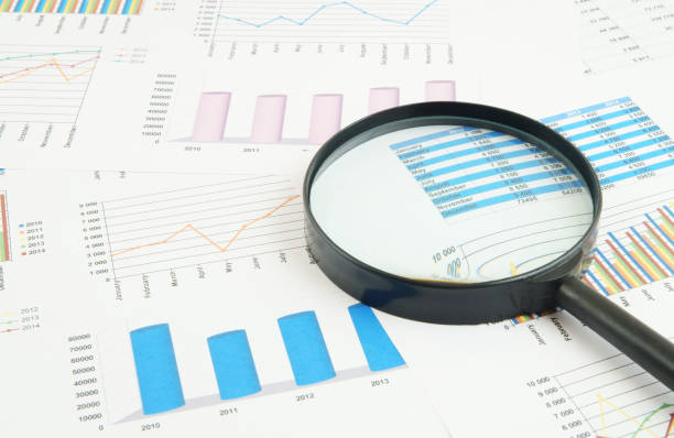 istock Magnifying glass on financial charts and graphs 1281758096