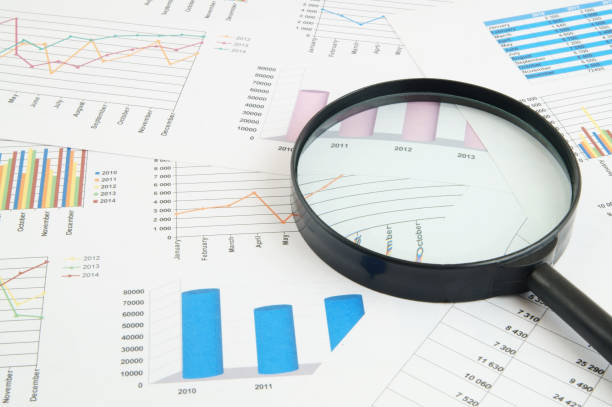 istock Magnifying glass on financial charts and graphs 1281758100