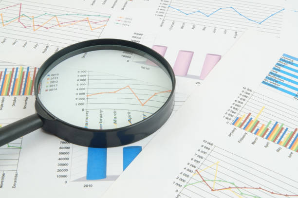 istock Magnifying glass on financial charts and graphs 1281758105