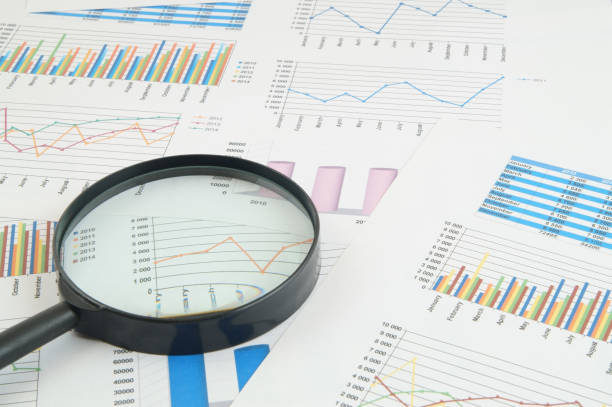 istock Magnifying glass on financial charts and graphs 1281758128