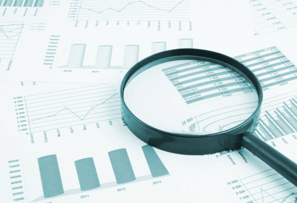istock Magnifying glass on financial charts and graphs 1281758130