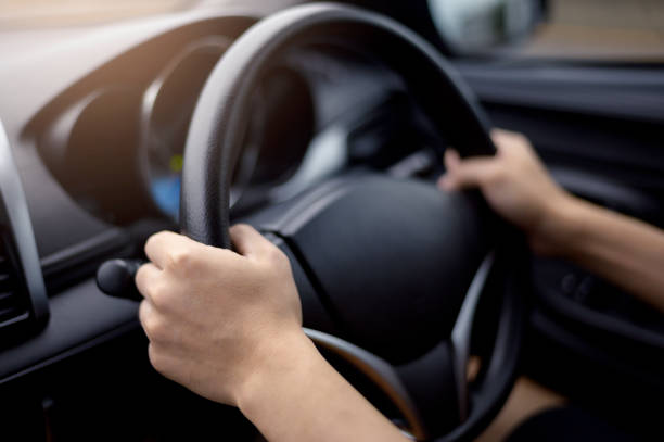 istock Background of human hand is holding car steering . 1281758188