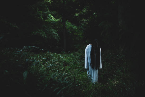 Spooky Japanese ghost woman in a forest A creepy long black hair Japanese ghost woman in a dark forest. witch photos stock pictures, royalty-free photos & images