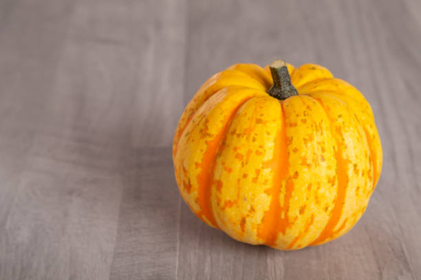 istock Colored beautiful pumpkin lies on a wooden background 1281761103
