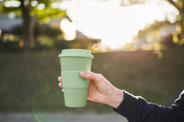 A woman holding a reusable coffee cup