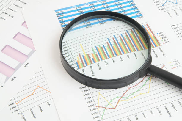 istock Magnifying glass on financial charts and graphs 1281763862