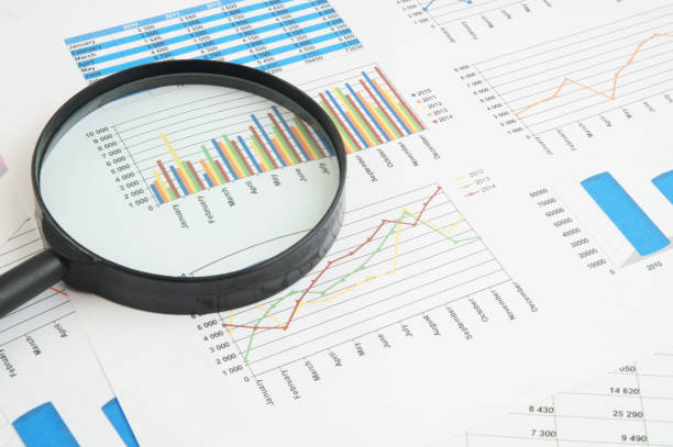 istock Magnifying glass on financial charts and graphs 1281763891