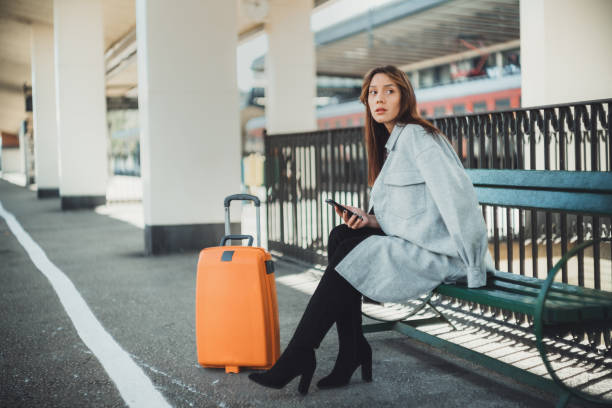 istock Woman sitting on the bench waiting for a train 1281764029