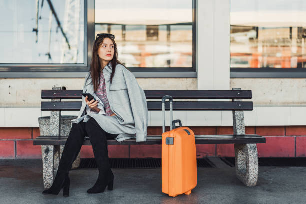 istock Woman sitting on the bench waiting for a train 1281764038
