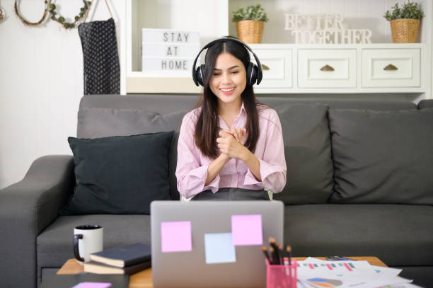istock A beautiful young woman wearing headset is making video conference call via computer at home , business technology concept . 1281764143