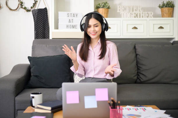 istock A beautiful young woman wearing headset is making video conference call via computer at home , business technology concept . 1281764149