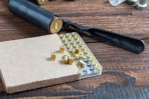 Shotgun shells reloading process with special reload equipment. Powder, bullets, fraction, shells, buckshot on the wooden background. Shotgun shells reloading process with special reload equipment. Powder, bullets, fraction, shells, buckshot on the wooden background. birch gold group review kit stock pictures, royalty-free photos & images