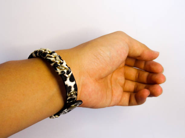 istock bracelet in black gold holding on hand on white background 1281765211
