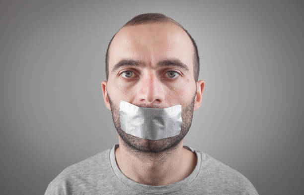 istock Caucasian man with tape on mouth. Censorship 1281766427