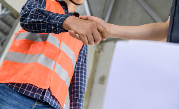 istock Asian Engineer and architect handshake at construction property site. Teamwork and Successful housing estate building project 1281766592