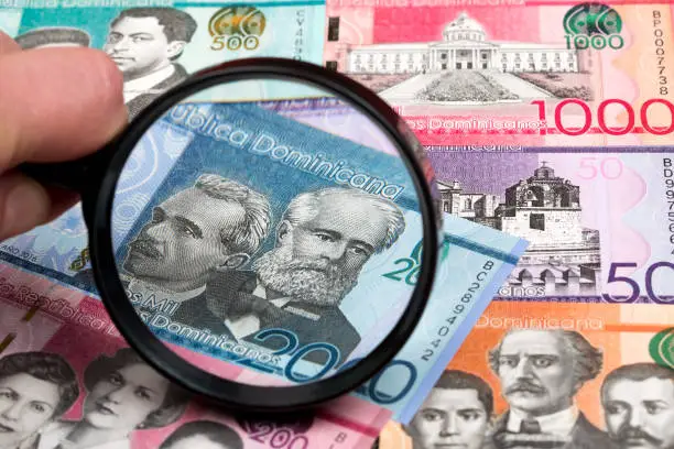Dominican peso in a magnifying glass a business background