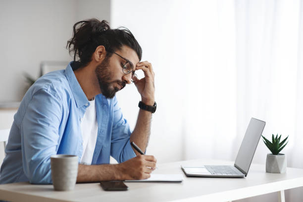 istock Concentrated Indian Freelancer Guy Noting Ideas To Notepad, Working At Home Office 1281768251