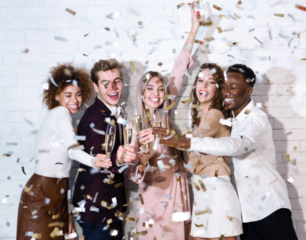 istock Diverse Guys And Girls Clinking Glasses Under Falling Confetti Indoor 1281768543