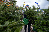 Woman with protective mask selecting a Christmas tree at an outside market