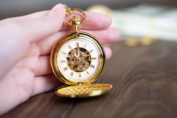 un uomo tiene in mano un orologio da tasca vintage. - bare tree immagine foto e immagini stock