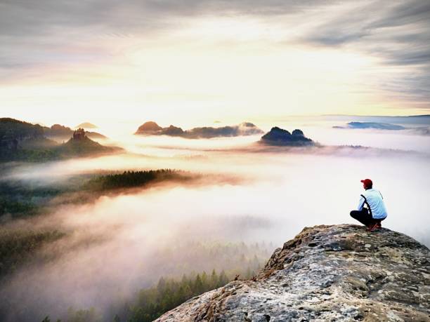 istock Hiker In White Black Clothes On Cliff Edge Looking To Misty Hilly Valley Bellow, Fall Season Begins 1281775512