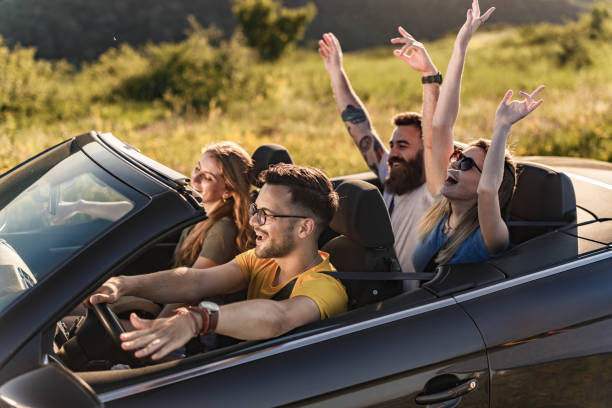 istock Young happy couples going on a road trip by convertible car. 1281775741