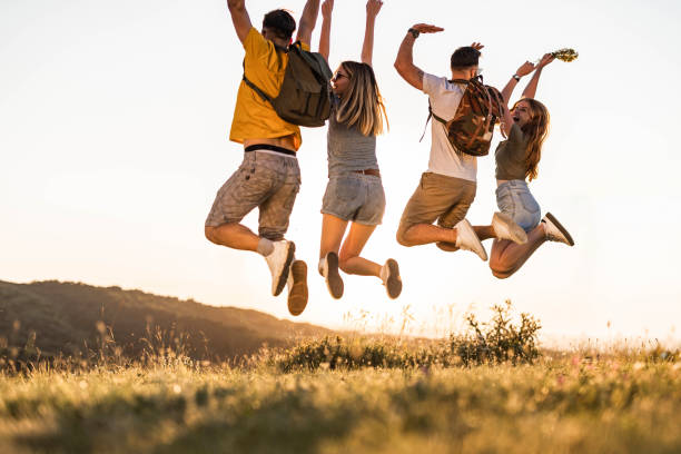 istock Rear view of playful friends having fun while jumping in nature. 1281776548