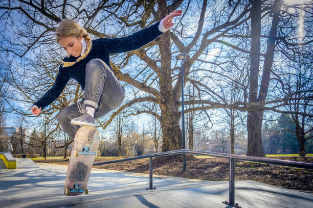 istock Young woman skateboarding in park 1281777493