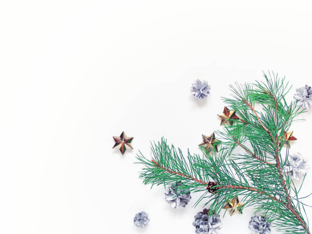istock Christmas composition. Pine branches with soft green needles are on a white background. There are silver cones and golden stars nearby. New Year, winter concept. Flat lay. Top view. Copy space. 1281778386