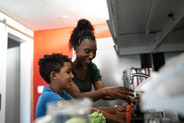 istock Mother teaching son how to clean vegetables at home 1281780010