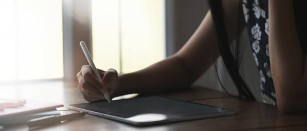 istock Cropped shot of female freelancer working on digital tablet while sitting next to window in office. 1281780018