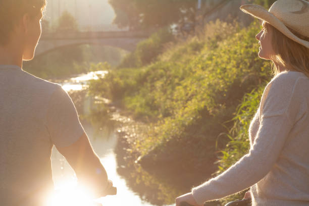 istock Two young adults meet with bicycles in the morning sunlight 1281781714