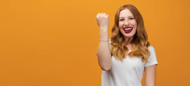 istock Successful girl making Winner gesture, standing yellow background. Copy space 1281783518