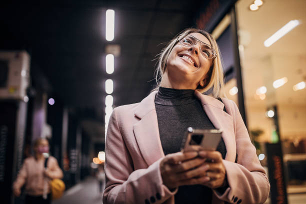 istock Beautiful woman standing next to store window and using smart phone 1281783945