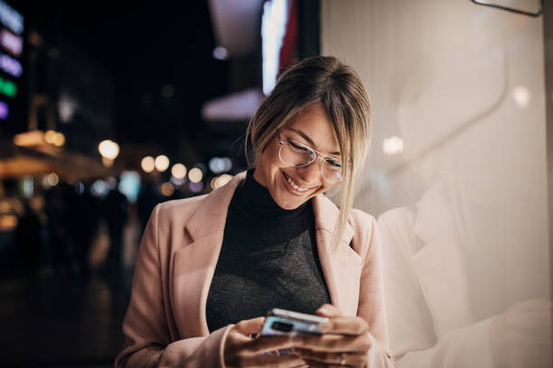 istock One beautiful young woman standing next to store window and using smart phone 1281783978