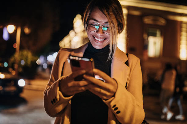 istock One beautiful woman using smart phone outdoors in the city at night 1281784863