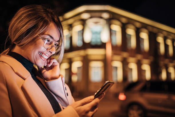 istock One happy woman using smart phone outdoors in the city at night 1281784986