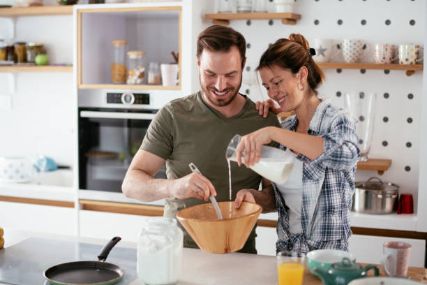 istock Husband and wife making pancakes at home. 1281785029