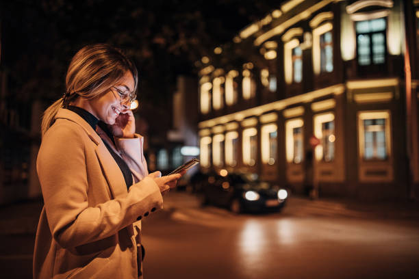 istock One young woman using smart phone outdoors in the city at night 1281785140
