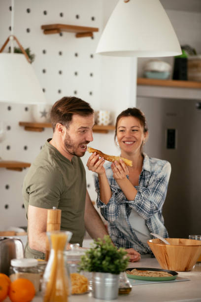 istock Husband and wife making pancakes at home. 1281785183