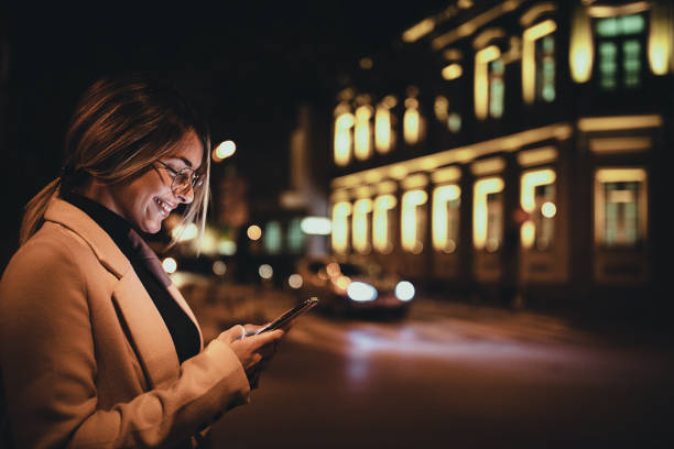istock One woman using smart phone outdoors in the city at night 1281785218