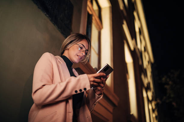istock One woman using mobile phone outdoors in the city at night 1281786207