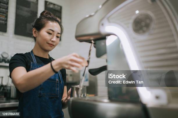 An Asian Chinese Female Barista Making Coffee With Coffee Machine At The Cafe Stock Photo - Download Image Now