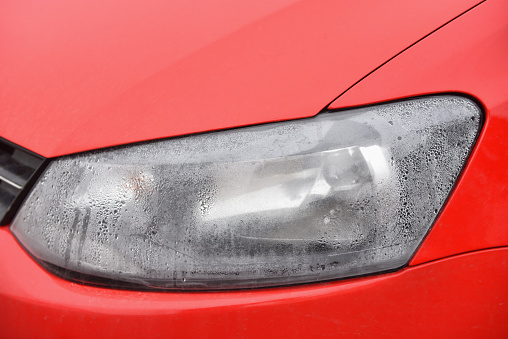 Foggy headlight with condensation in a modern car.