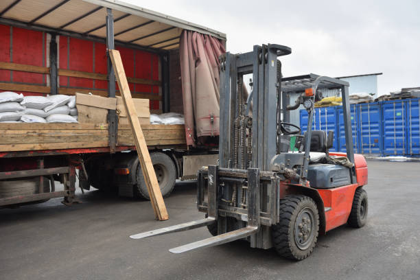 istock Red forklift stands next to a truck trailer 1281789177