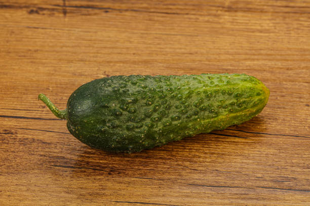 istock Green ripe fresh cucumber over background 1281789284