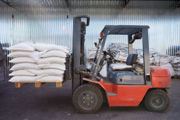 istock Red forklift lifts pallet with white bags 1281789699