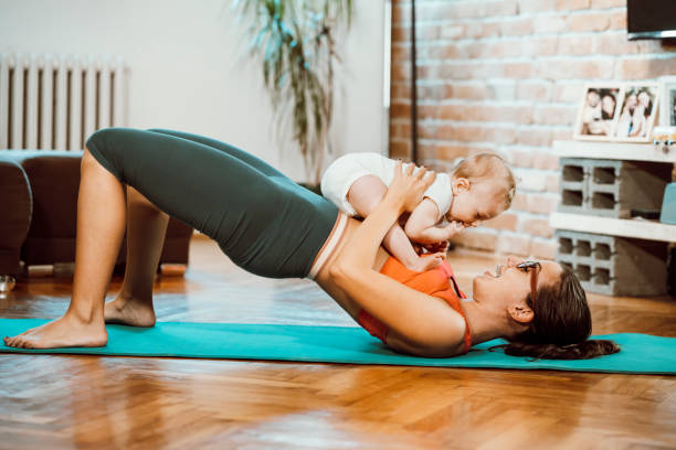 istock Woman exercising at home with baby 1281791092