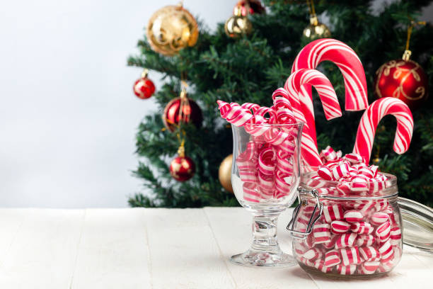 istock Different kinds of Christmas candy in glass jars, Christmas tree on background, horizontal, copy space 1281791127